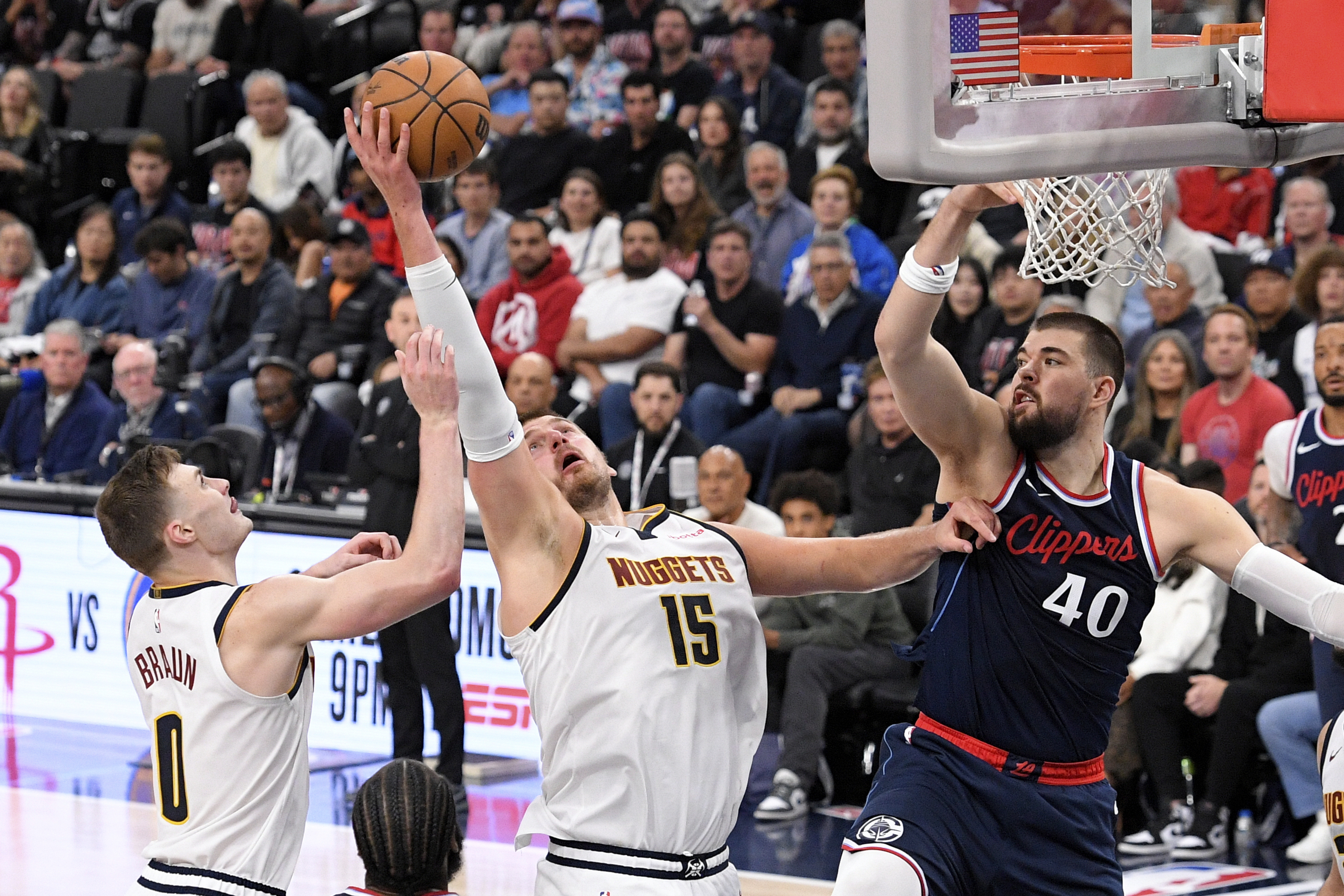 Denver Nuggets center Nikola Jokic, center, grabs a rebound away from Los Angeles Clippers center Ivica Zubac, right, as guard Christian Braun reaches during the second half in Game 6 of an NBA basketball first-round playoff series Thursday, May 1, 2025, in Inglewood, Calif.