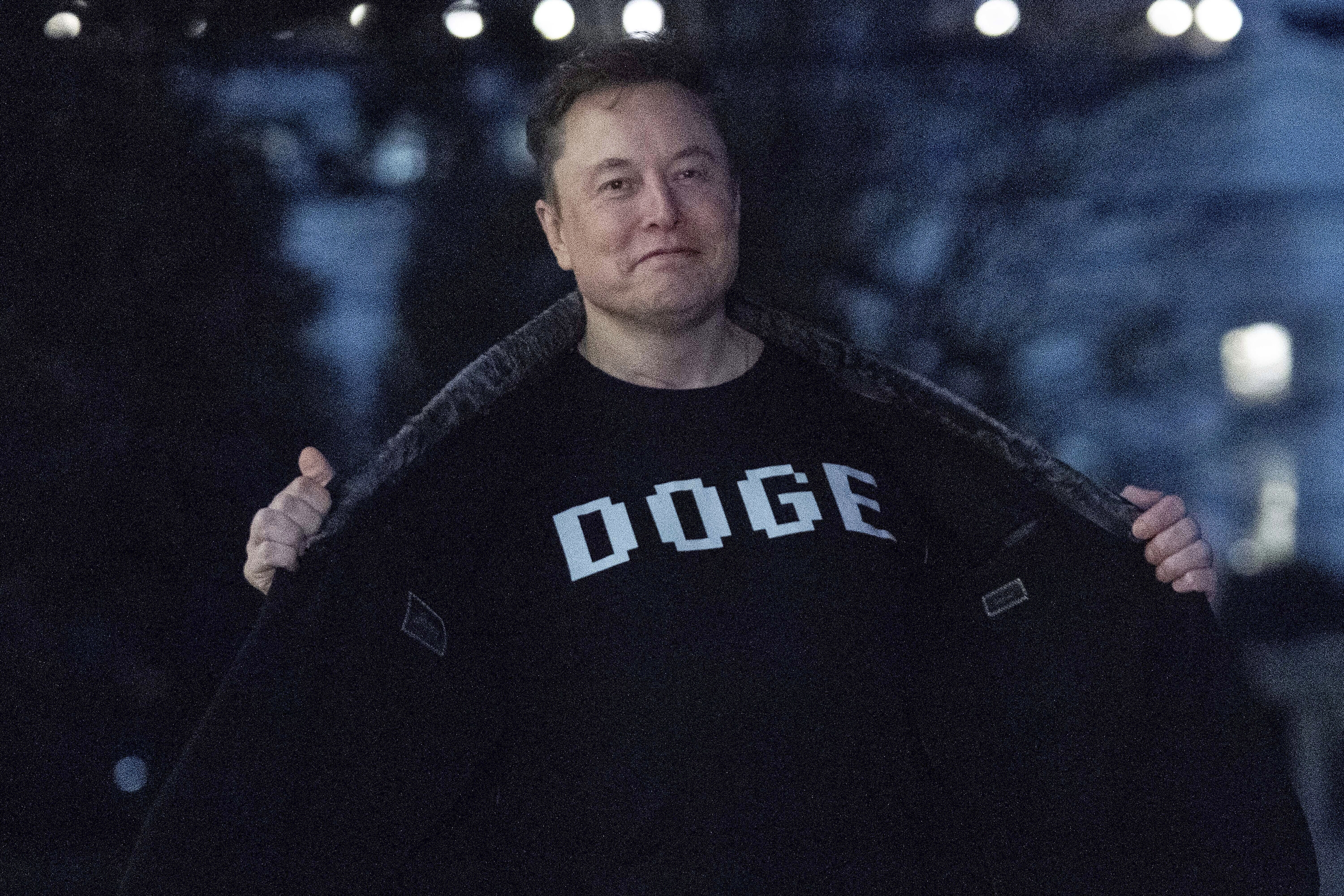 Elon Musk flashes a T-shirt that reads "DOGE" to the media as he walks on South Lawn of the White House, in Washington, March 9. The relationship between DOGE and lawmakers in D.C. has appeared to break down.