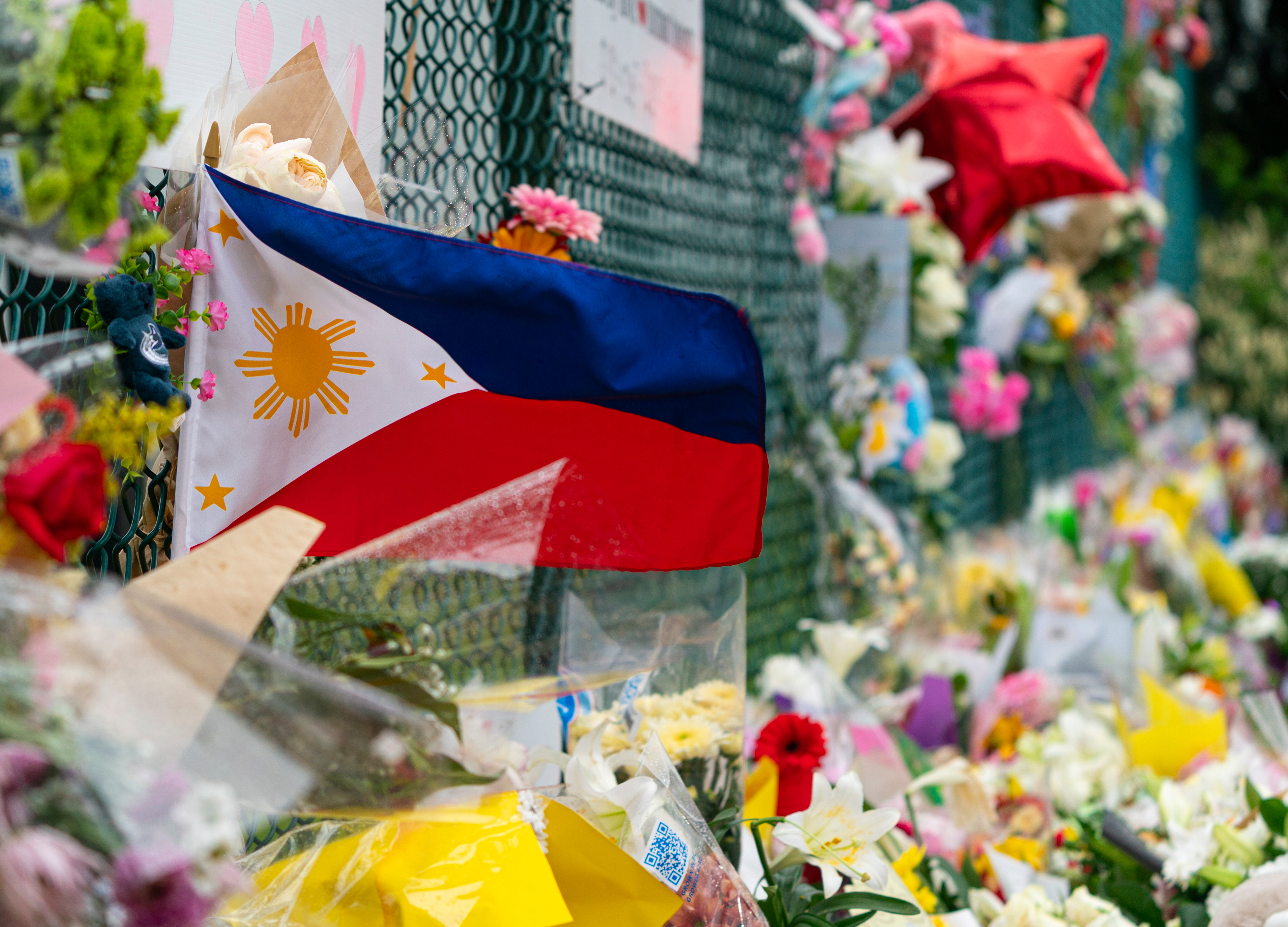 A Philippines flag waves in the wind at a memorial site for the victims of an incident where a car drove through a crowd, killing multiple people in Vancouver, British Columbia, Monday.