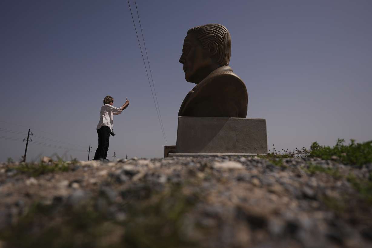 A visitor photographs a large bust of Elon Musk near SpaceX's Starbase as the Starship is prepared for a test flight in Boca Chica, Texas, March 5.