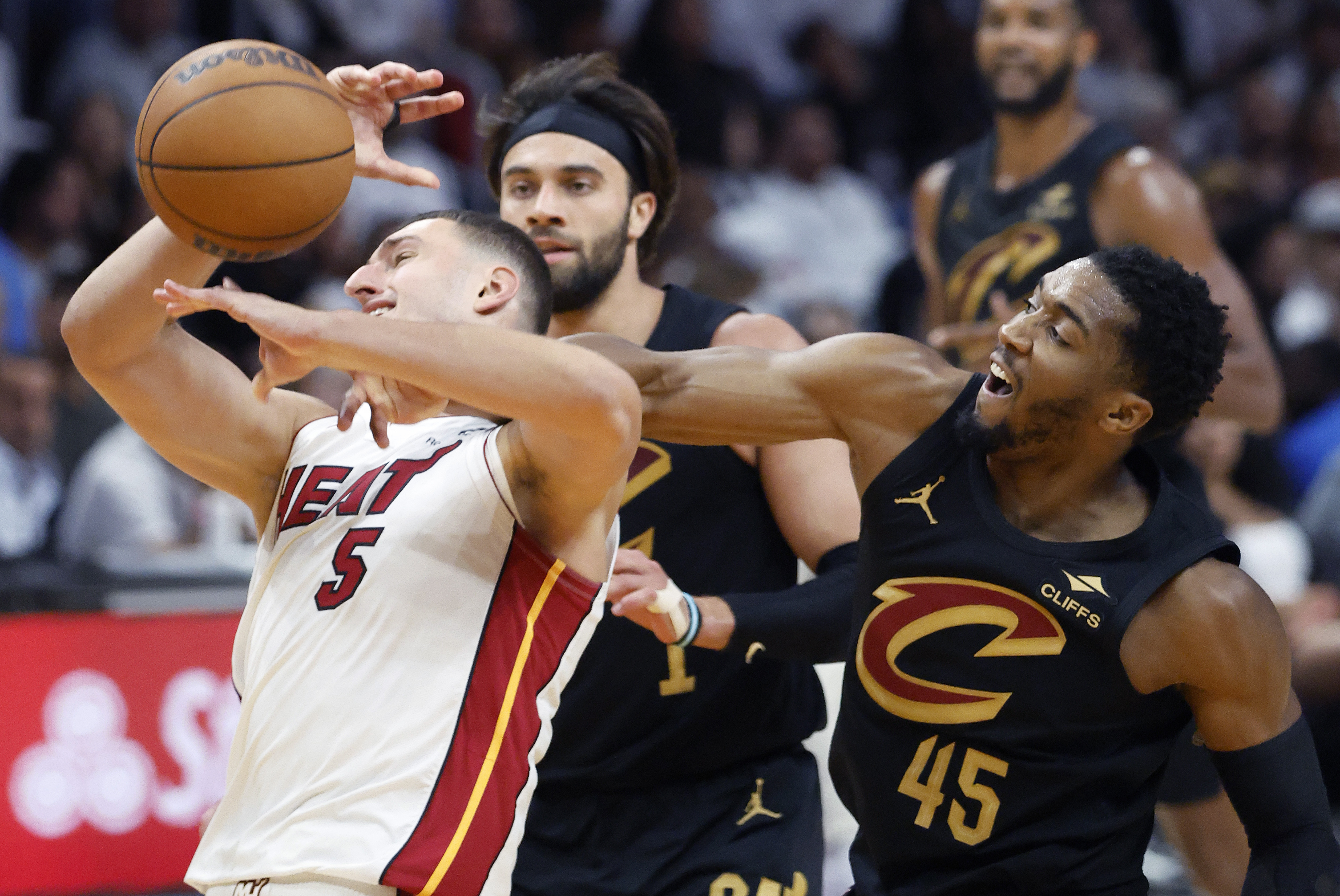 Cleveland Cavaliers guard Donovan Mitchell (45) fouls Miami Heat forward Nikola Jovic (5) during the first half in Game 4 of an NBA basketball first-round playoff series, Monday, April 28, 2025, in Miami.