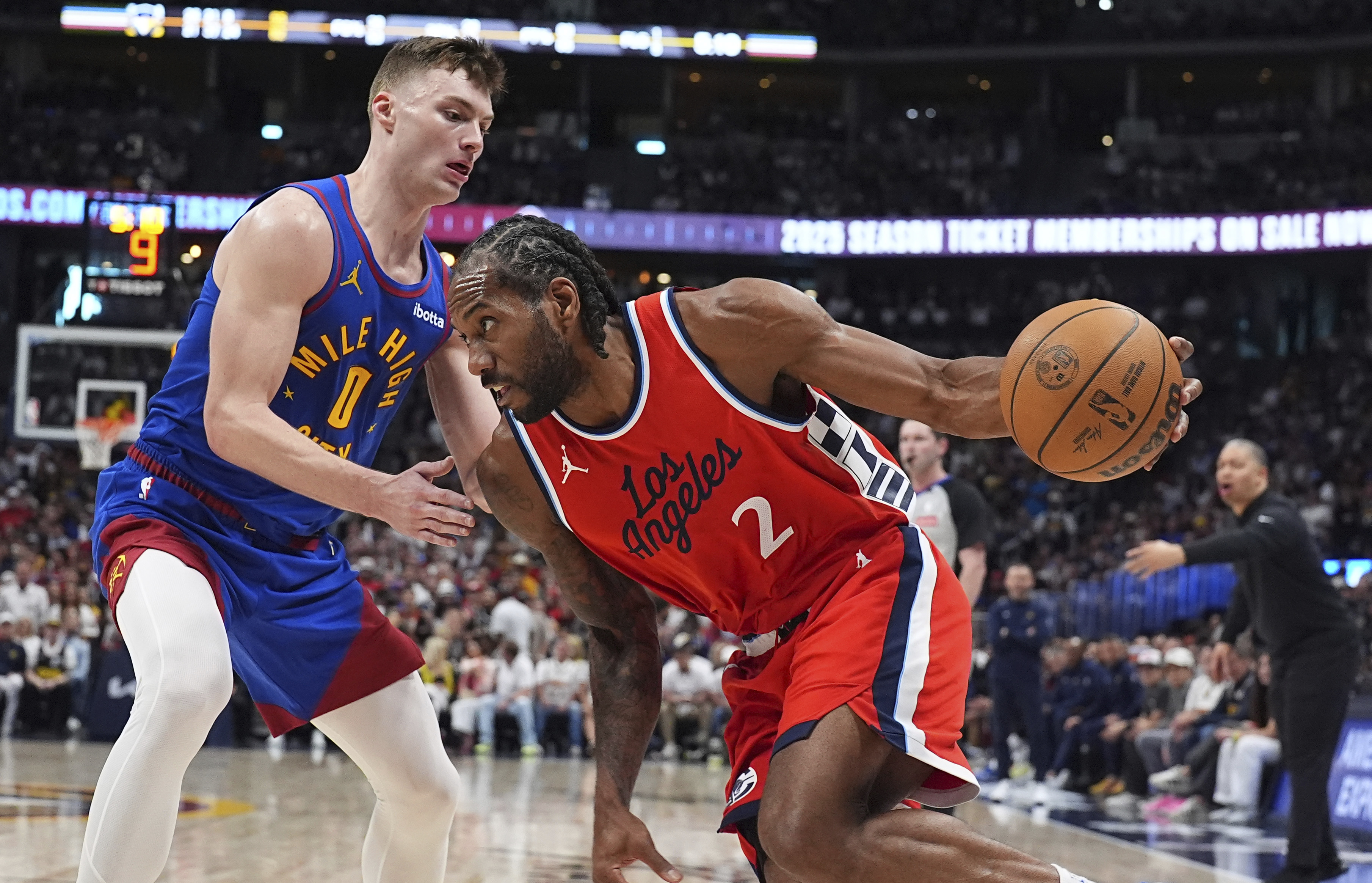 Los Angeles Clippers forward Kawhi Leonard, right, drives to the basket as Denver Nuggets guard Christian Braun, left, defends in the second half of Game 7 of an NBA basketball first-round playoff series Saturday, May 3, 2025, in Denver.