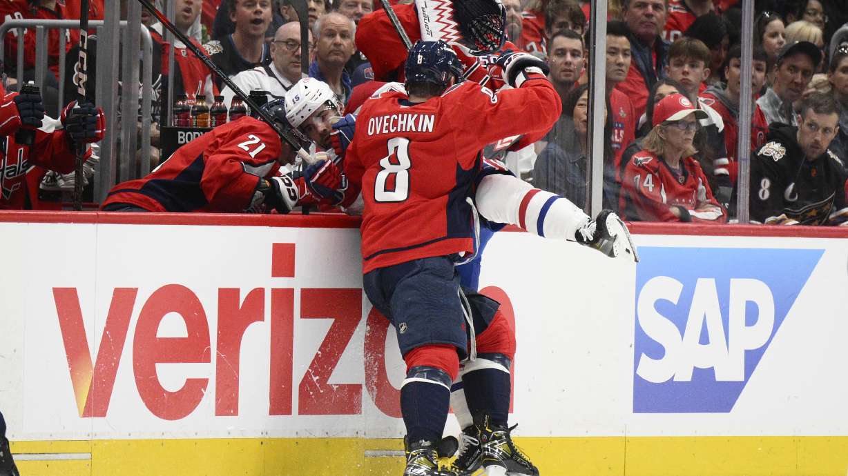 Washington Capitals left wing Alex Ovechkin (8) hits Montreal Canadiens center Alex Newhook (15) into the bench area in the second period of Game 5 of a first-round NHL hockey playoff series Wednesday, April 30, 2025, in Washington.
