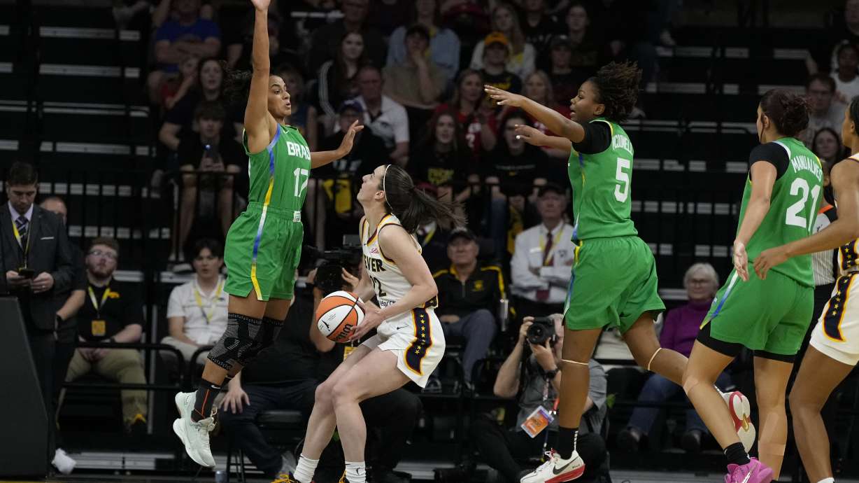 Indiana Fever guard Caitlin Clark, second from left, drives to the basket between Brazil guard Carina Martins, left, and forward Ayla McDowell (5) during the first half of an exhibition women's basketball game, Sunday, May 4, 2025, in Iowa City, Iowa.