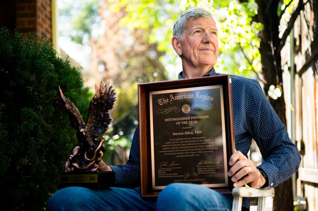 Dr. Steve Allen poses with his Zions Bank Lifetime of Service award, left, and "Distinguished Physician of the Year" award from The American Legion, right, at his home in Salt Lake City on April 21. Allen won the “Distinguished Physician of the Year” award for his work with veterans suffering from PTSD and recently retired after 40 years at the George E. Wahlen Department of Veterans Affairs Medical Center.