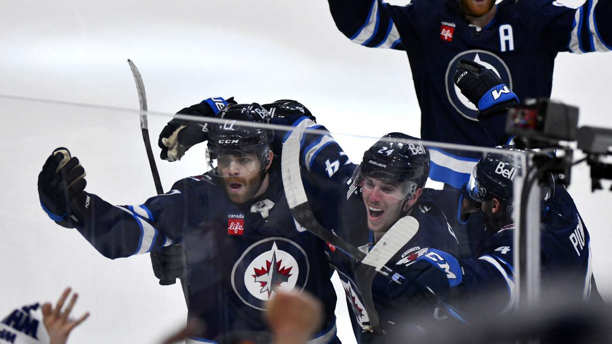 Winnipeg Jets' Adam Lowry (17) celebrates his game-winning goal against the St. Louis Blues with Haydn Fleury (24) in the second overtime period of Game 7 in an NHL hockey first-round playoff series in Winnipeg, Manitoba, Sunday, May 4, 2025.