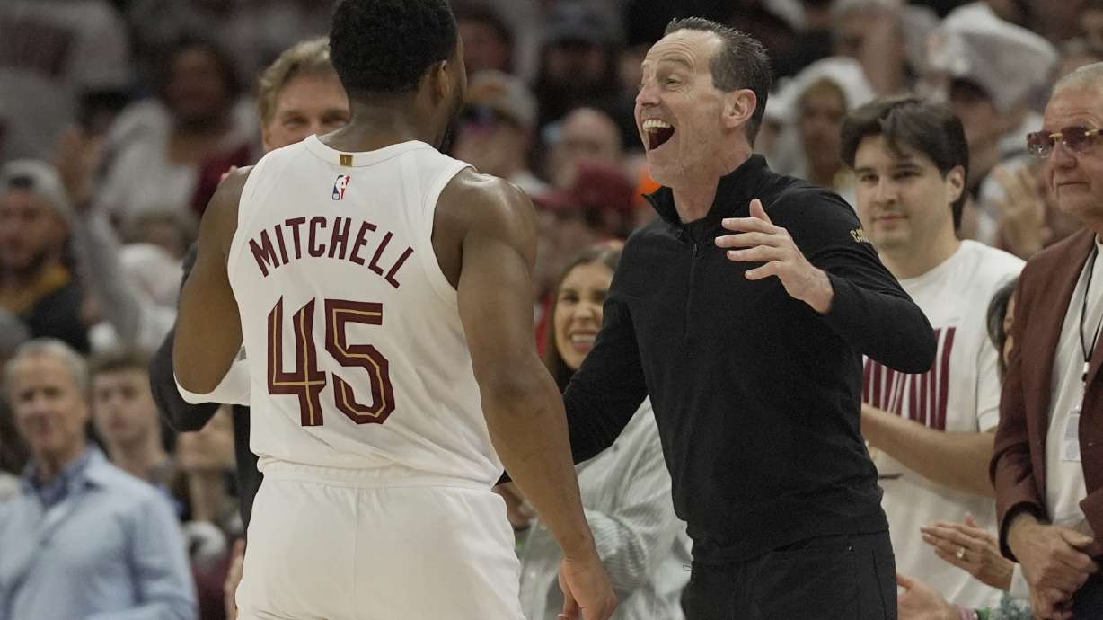 Cleveland Cavaliers head coach Kenny Atkinson, right, greets guard Donovan Mitchell (45) as he returns to the bench late in the second half in Game 1 of an NBA first-round playoff series against the Miami Heat, Sunday, April 20, 2025, in Cleveland.