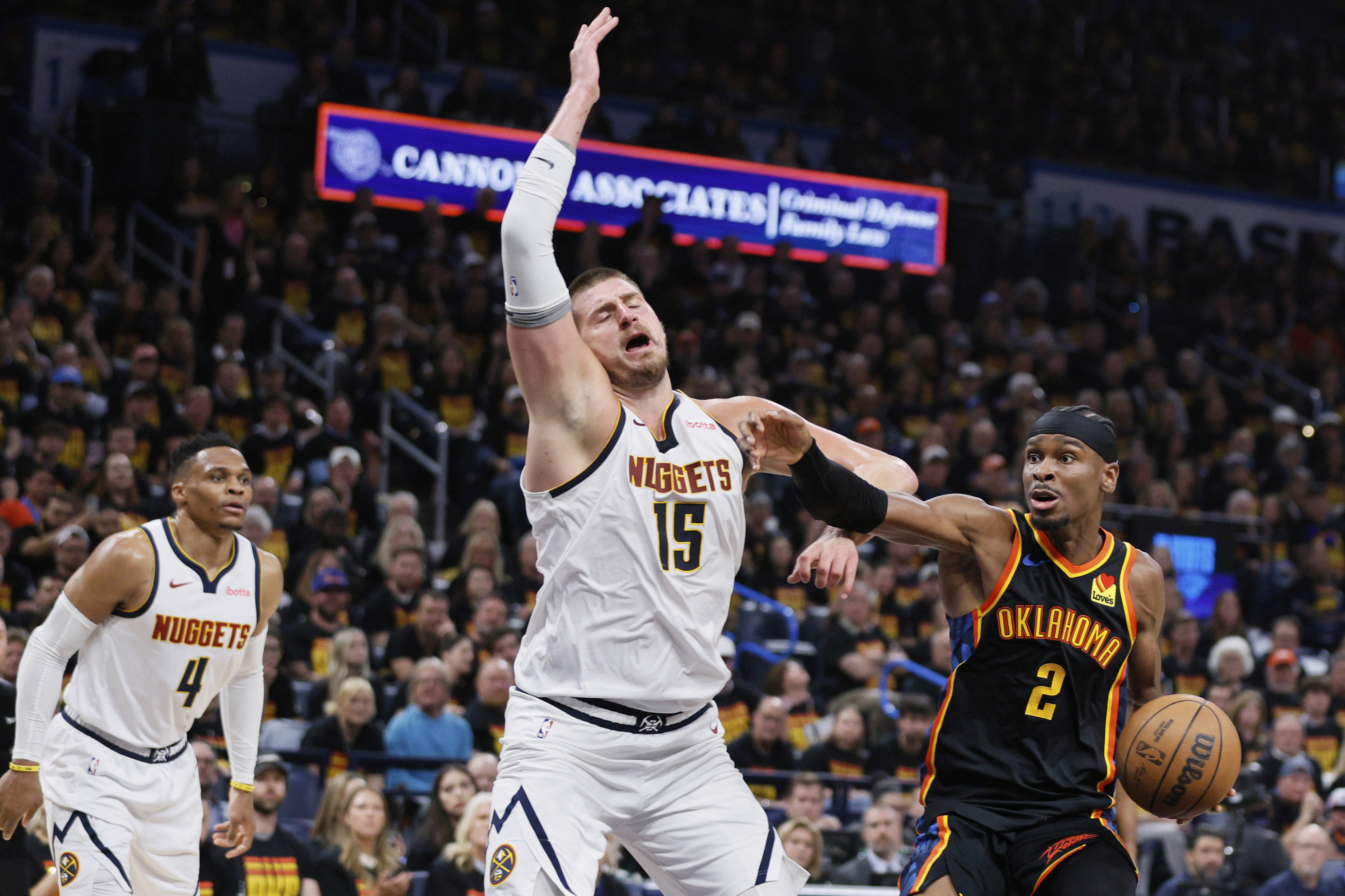 Oklahoma City Thunder's Shai Gilgeous-Alexander (2) works to the basket as Denver Nuggets' Nikola Jokic (15) and Russell Westbrook (4) defend in the second half of Game 1 of an NBA basketball second-round playoff series Monday, May 5, 2025, in Oklahoma City. 