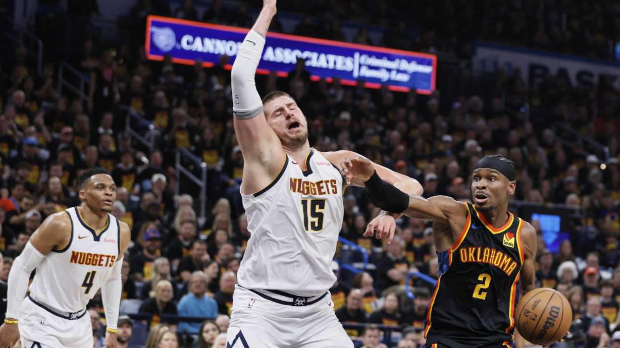 Oklahoma City Thunder's Shai Gilgeous-Alexander (2) works to the basket as Denver Nuggets' Nikola Jokic (15) and Russell Westbrook (4) defend in the second half of Game 1 of an NBA basketball second-round playoff series Monday, May 5, 2025, in Oklahoma City.