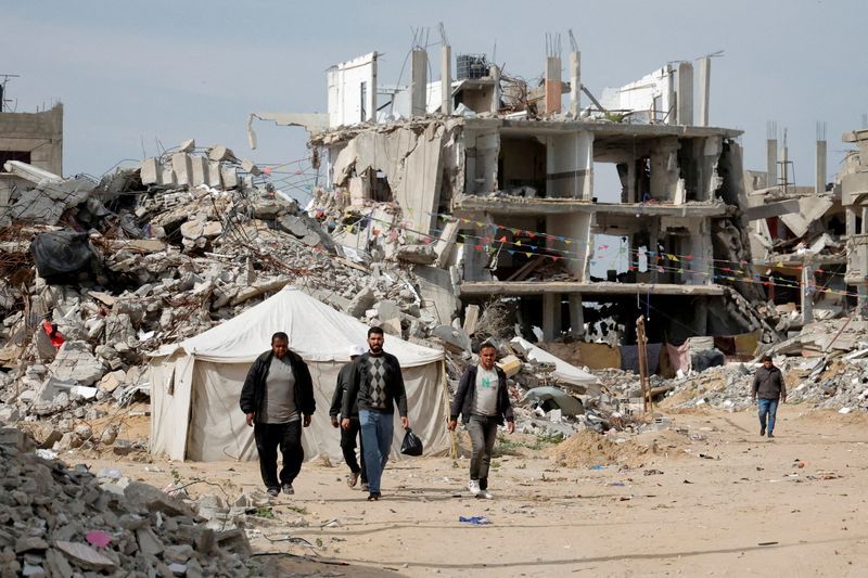 Palestinian men walk near rubble of houses destroyed during the Israeli offensive, in Rafah, in the southern Gaza Strip, March 13.