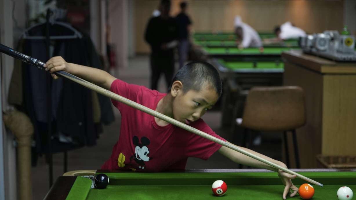 Li Zelei, 8 years old, practice on a pool table at the Beijing Xinrui Billiard Academy in Beijing, Tuesday, May 6, 2025.