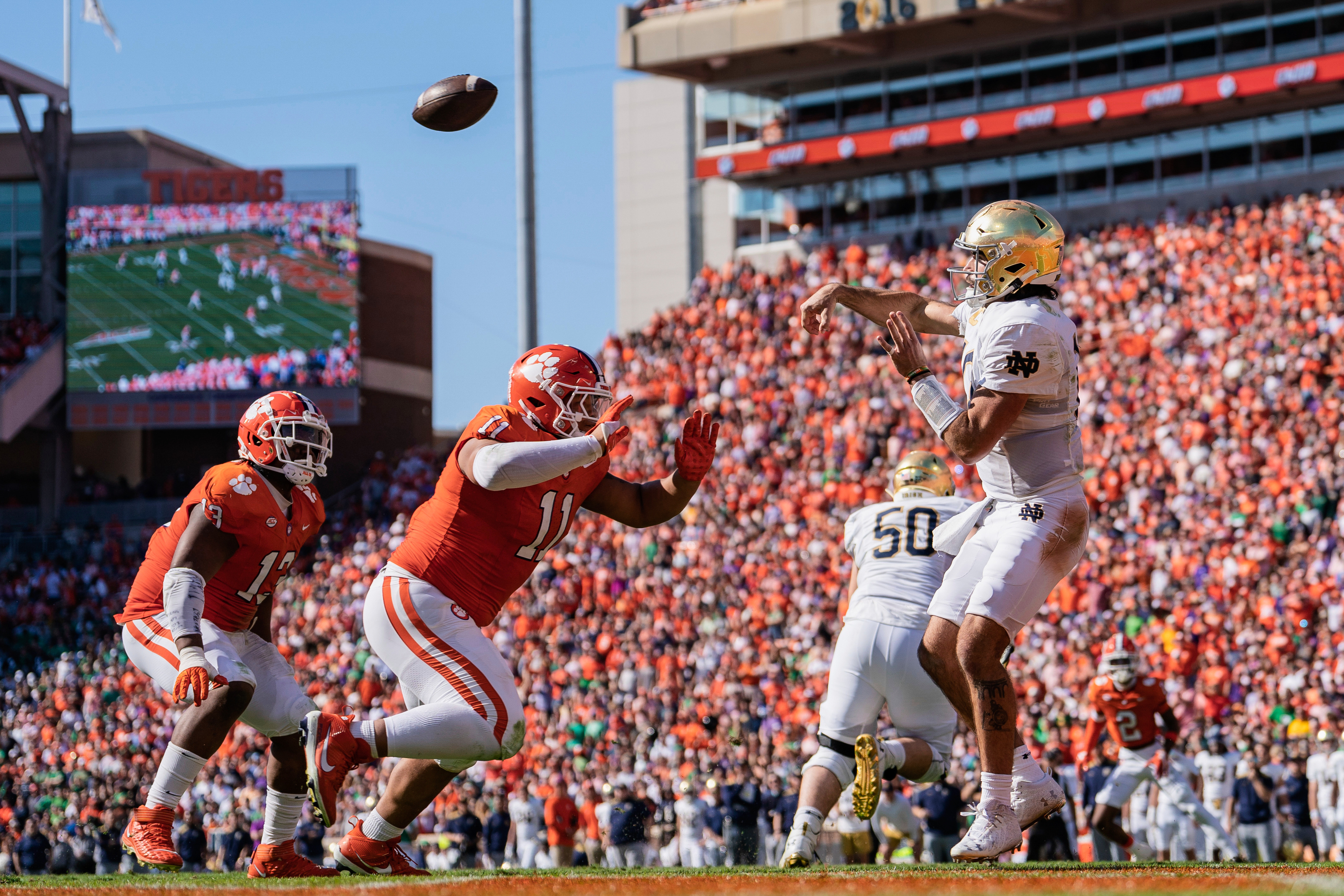 FILE - Notre Dame quarterback Sam Hartman (10) passes the ball while pressured by Clemson defensive tackle Peter Woods (11) during an NCAA college football game Saturday, Nov. 4, 2023, in Clemson, S.C.