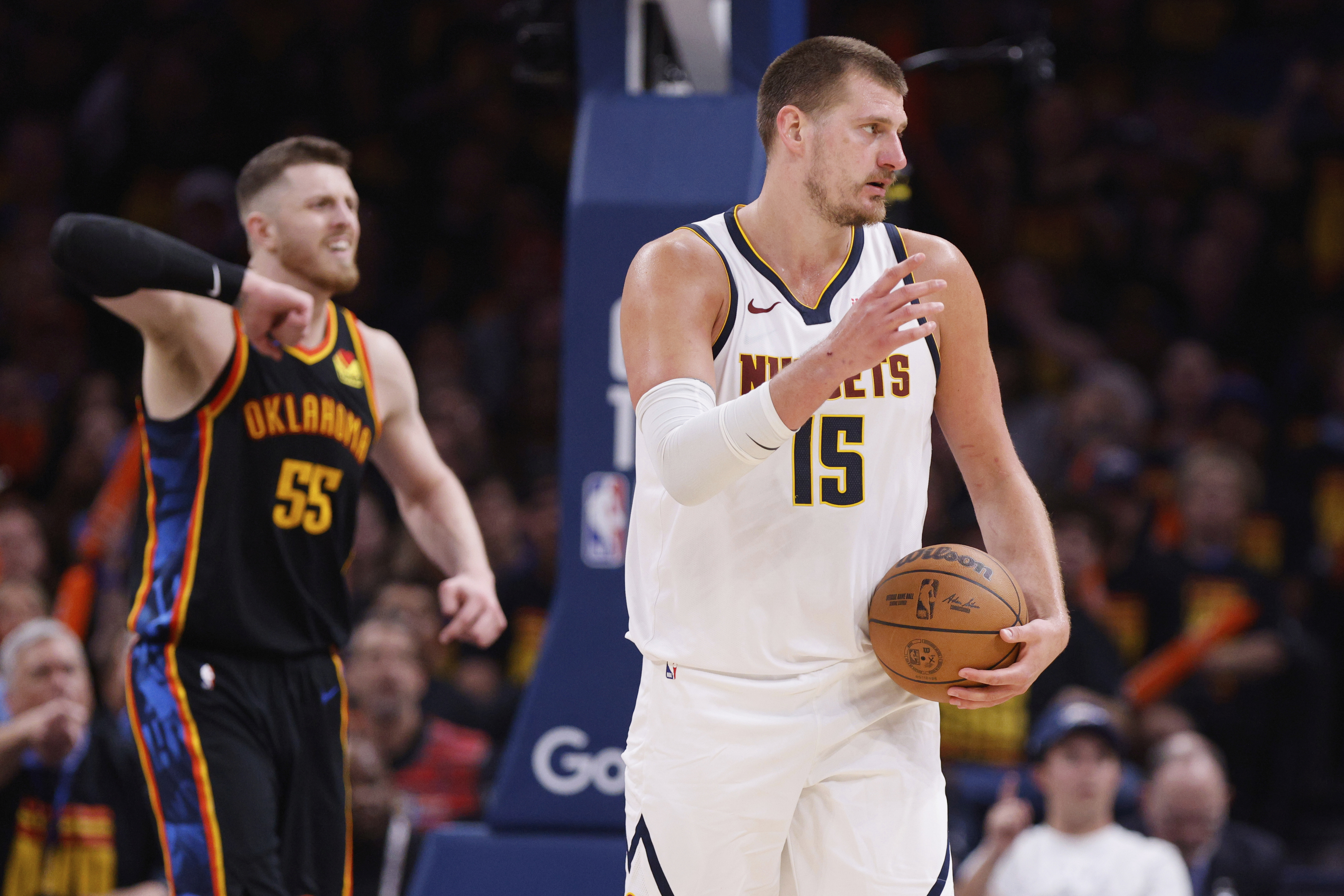 Denver Nuggets' Nikola Jokic (15) and Oklahoma City Thunder's Isaiah Hartenstein (55) react to an officials call in the second half of Game 1 of an NBA basketball second-round playoff series Monday, May 5, 2025, in Oklahoma City.