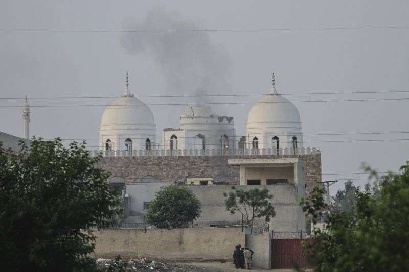 Local residents stand outside a mosque of an Islamic seminary partially damaged by a suspected Indian missile attack, outskirts of Bahawalpur, Pakistan, Wednesday.