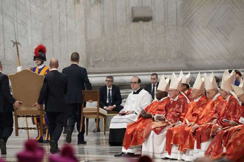 A chair is taken away at the end of a final Mass celebrated by cardinals inside St. Peter's Basilica, before the conclave to elect a new pope, at the Vatican, Wednesday.