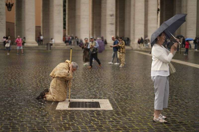 A person prays in St. Peter's Square during a final Mass by cardinals ahead of the conclave, at the Vatican, Wednesday.
