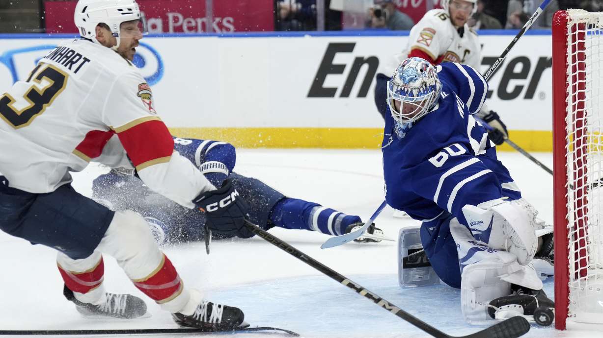 Toronto Maple Leafs goaltender Joseph Woll, front right, makes a save against Florida Panthers forward Sam Reinhart, left, during the third period of Game 1 in an NHL hockey second-round playoff series in Toronto, Monday, May 5, 2025.
