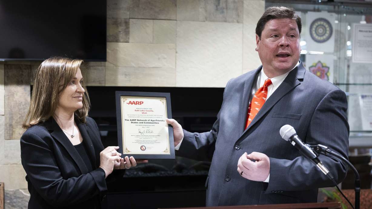 Salt Lake County Mayor Jenny Wilson gets a certificate from Alan Ormsby at a press conference to announce Salt Lake County’s designation as an AARP Age-Friendly Community at the Millcreek Community Center on Wednesday.