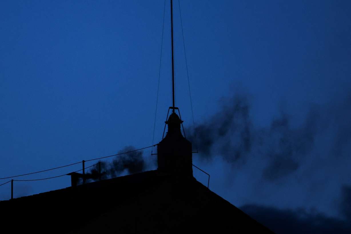 Black smoke rises from the chimney on the Sistine Chapel, indicating no decision has been made to elect a new pope, at the Vatican, Wednesday.