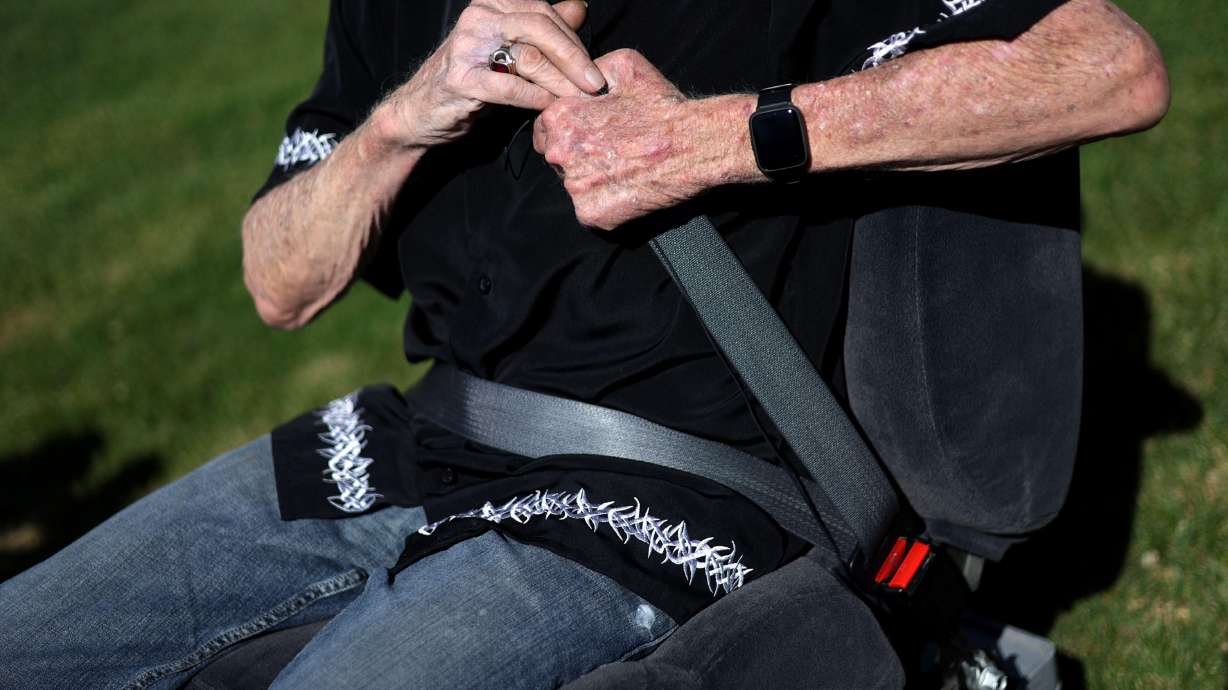 Skip Olsen demonstrates how to fasten a seat belt at the Mt. Olympus Senior Center in Millcreek on Thursday. The Utah Department of Public Safety urges children and older adults to buckle up.