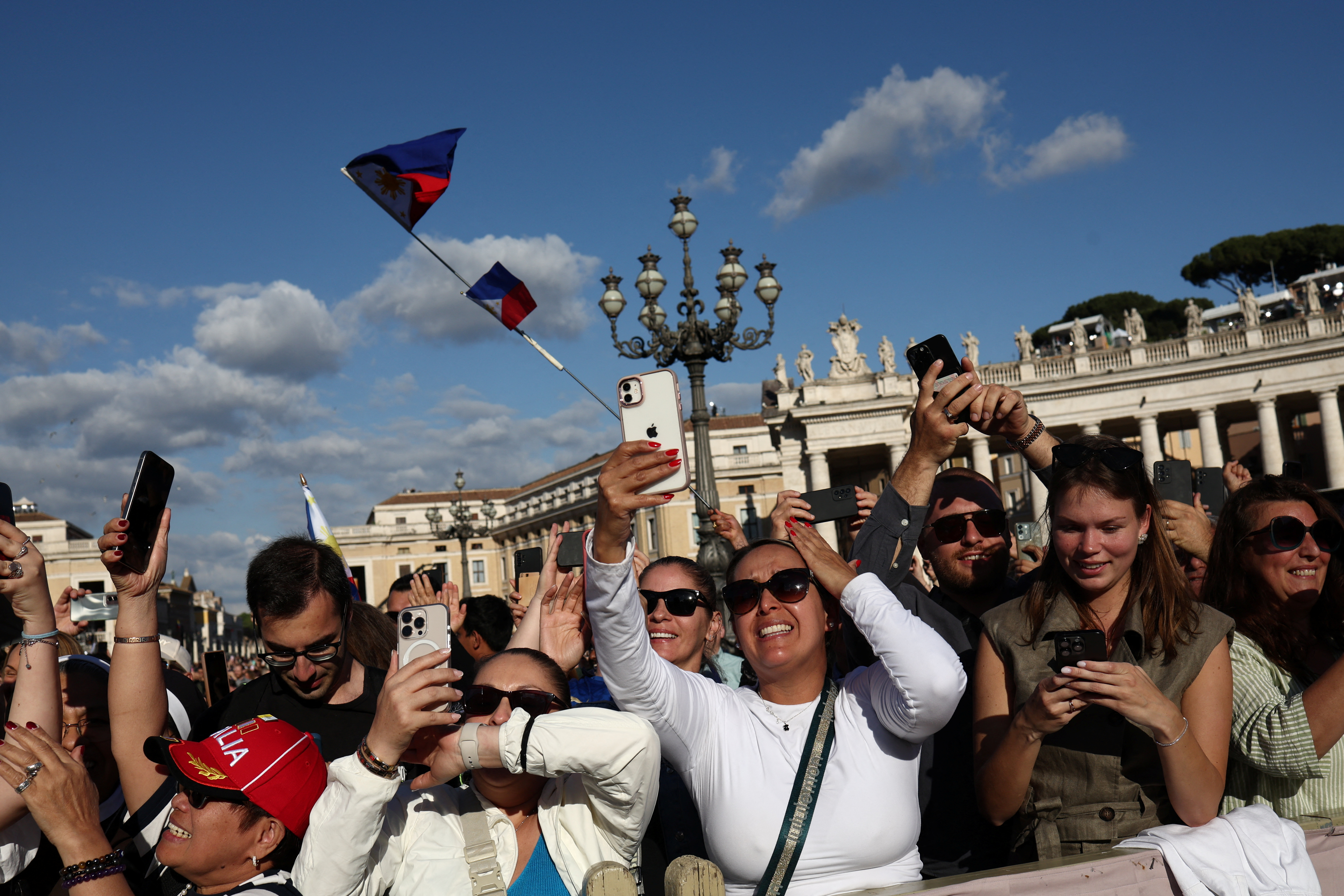 Faithful react to the white smoke indicating that a new pope has been elected, at the Vatican, Thursday.