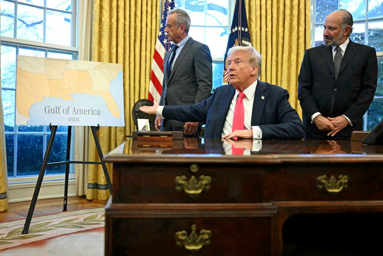 President Donald Trump gestures to a poster that says "Gulf of America" as Health and Human Services Secretary Robert F. Kennedy Jr., left, and Commerce Secretary Howard Lutnick watch in the Oval Office at the White House in Washington, Feb. 25.