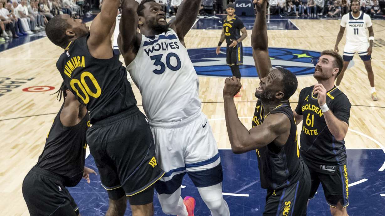 Minnesota Timberwolves' Julius Randle (30) shoots defended by four of the Golden State Warriors in the second half of Game 1 of an NBA basketball second-round playoff series, Tuesday, May 6, 2025, in Minneapolis.