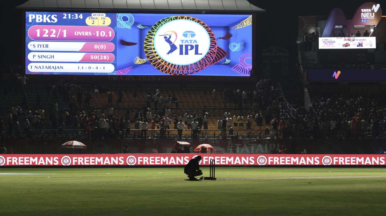 A worker removes the equipment placed next to the stumps after the authorities asked to evacuate the stadium during the Indian Premier League cricket match between Punjab Kings and Delhi Capitals at Himachal Pradesh Cricket Association Stadium in Dharamshala, India, Thursday, May 8, 2025.