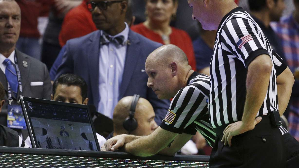 FILE - In this March 12, 2015, photo, officials review a play during an NCAA college basketball game between California and Arizona in the quarterfinals of the Pac-12 conference tournament in Las Vegas.