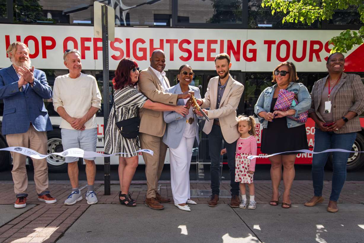 Maurice "Moe" Egan and local dignitaries cut a ribbon to celebrate the launch of the Salt Lake City Hop On Hop Off tour bus in Salt Lake City on Friday.
