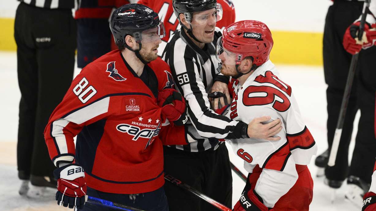 Washington Capitals left wing Pierre-Luc Dubois (80) and Carolina Hurricanes center Jack Roslovic (96) are separated by linesman Ryan Gibbons (58) in the third period of Game 2 of a second-round NHL hockey playoff series Thursday, May 8, 2025, in Washington.