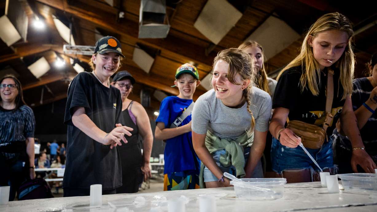 Wasatch Waldorf Charter School seventh grader Avery Rude, center, reacts after a film canister rocket popped during an experiment at USU Physics Day at Lagoon in Farmington on Friday.