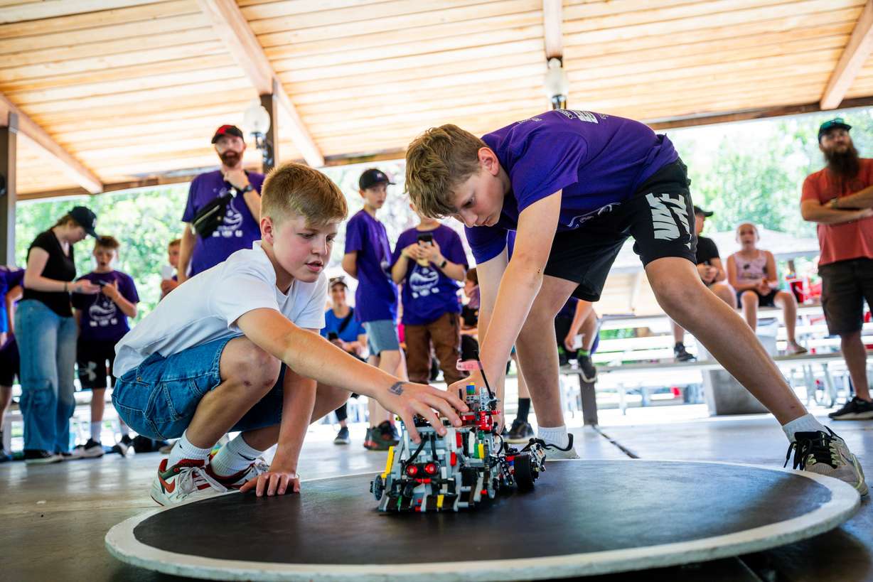 Sixth-graders Jake Coleman and Brenton Brown set up their robots to fight in robot sumo wrestling at USU Physics Day at Lagoon in Farmington on Friday.