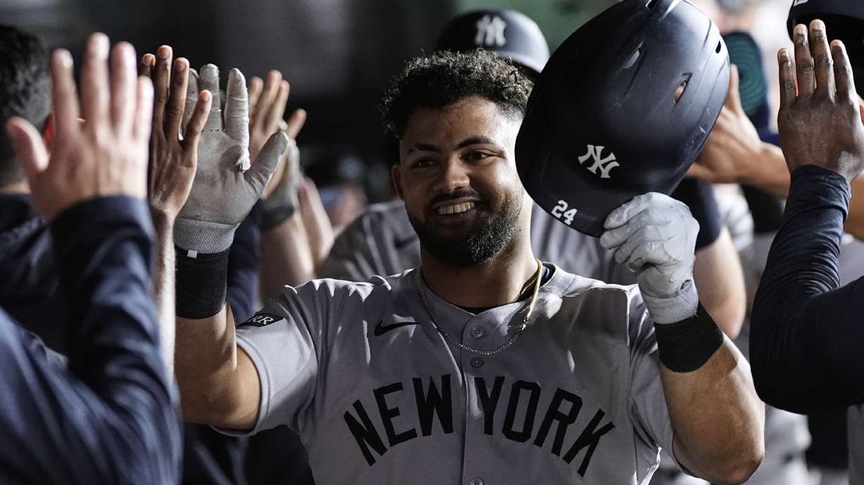 New York Yankees' Jasson DomÃnguez, center, is congratulated by teammates in the dugout after hitting a grand slam during the eighth inning of a baseball game against the Athletics, Friday, May 9, 2025, in West Sacramento, Calif.