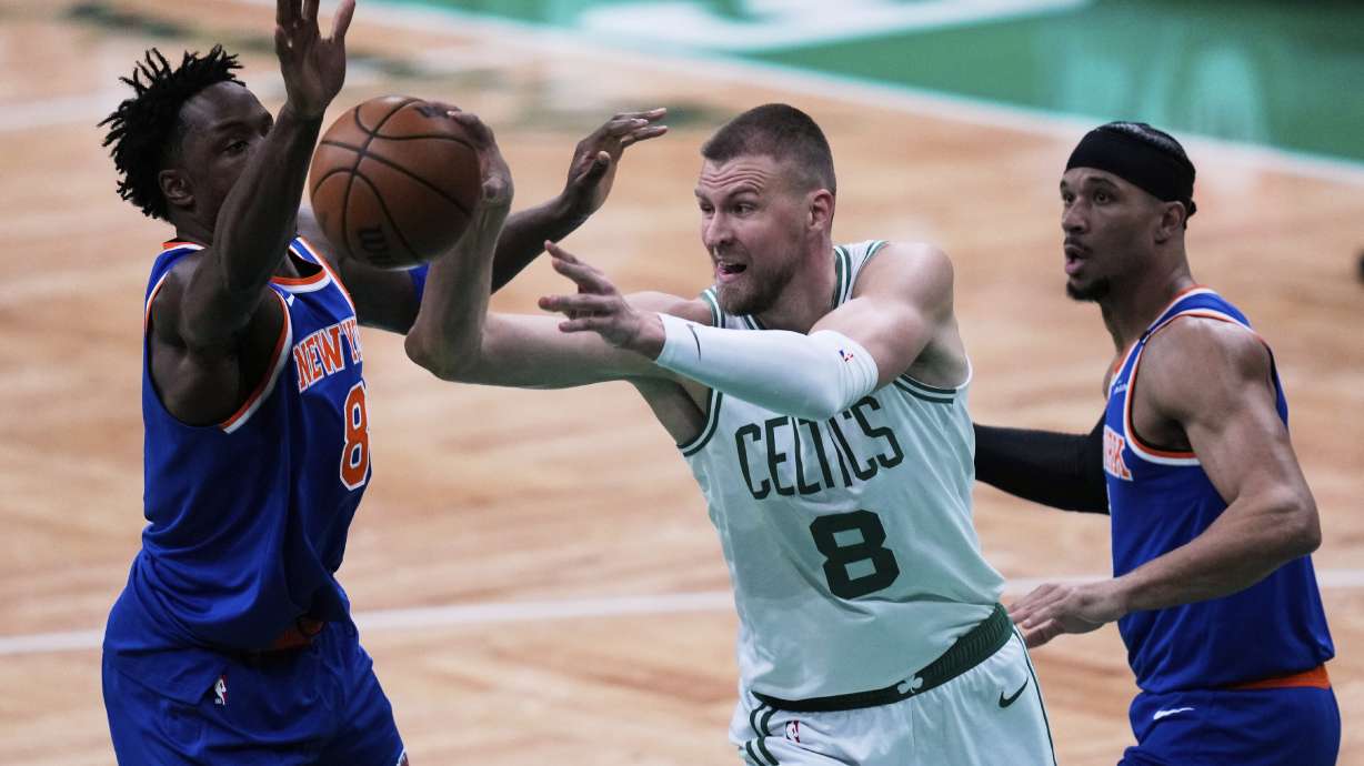 Boston Celtics center Kristaps Porzingis (8) passes the ball while pressured by the New York Knicks during the first half of Game 1 of an NBA basketball second-round playoff series Monday, May 5, 2025, in Boston.