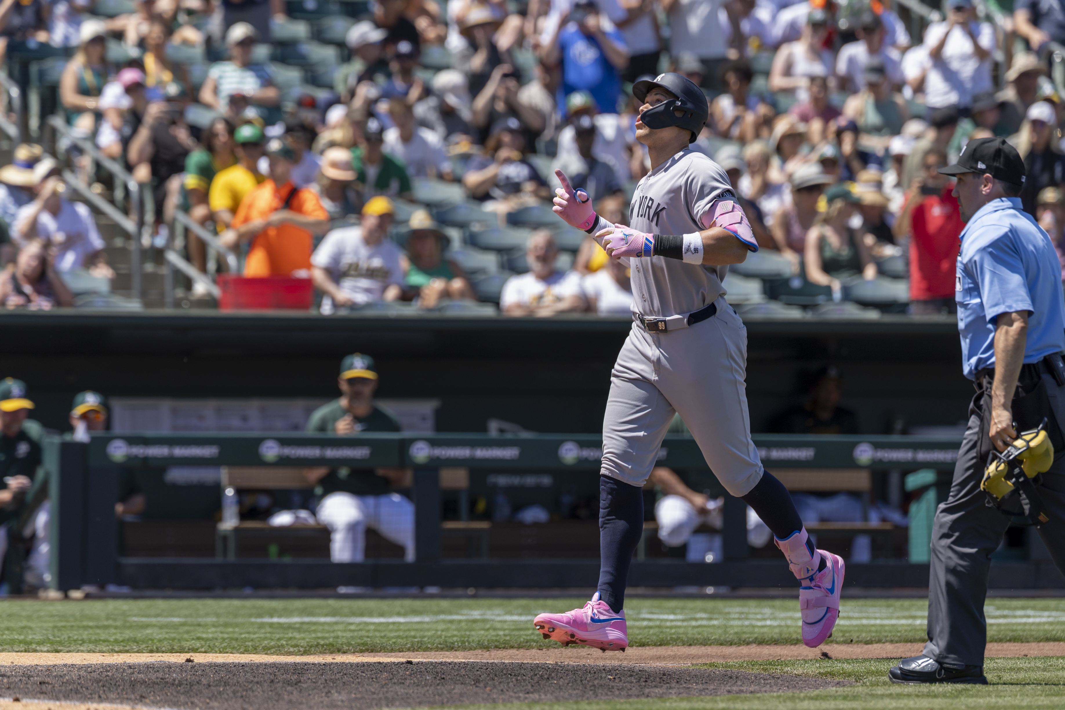 New York Yankees' Aaron Judge, left, points skyward after hitting a solo home run during the fourth inning of a baseball game against the Athletics, Saturday, May 10, 2025, in West Sacramento, Calif.