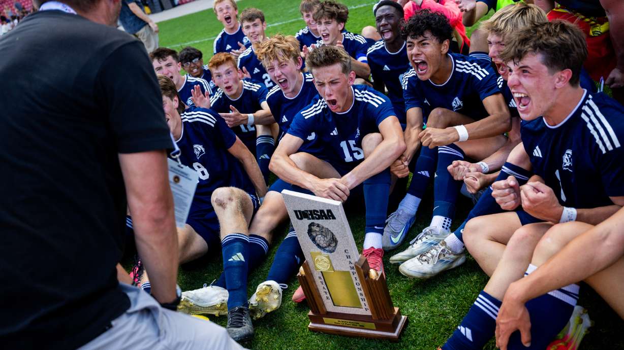Maeser Prep Academy Lions players celebrate with Maeser Prep Academy Lions head coach Dustin Simmons, left, after winning 3-1 against the American Heritage Patriots in the 2A boys soccer state championship at America First Field in Sandy on Saturday, May 10, 2025.