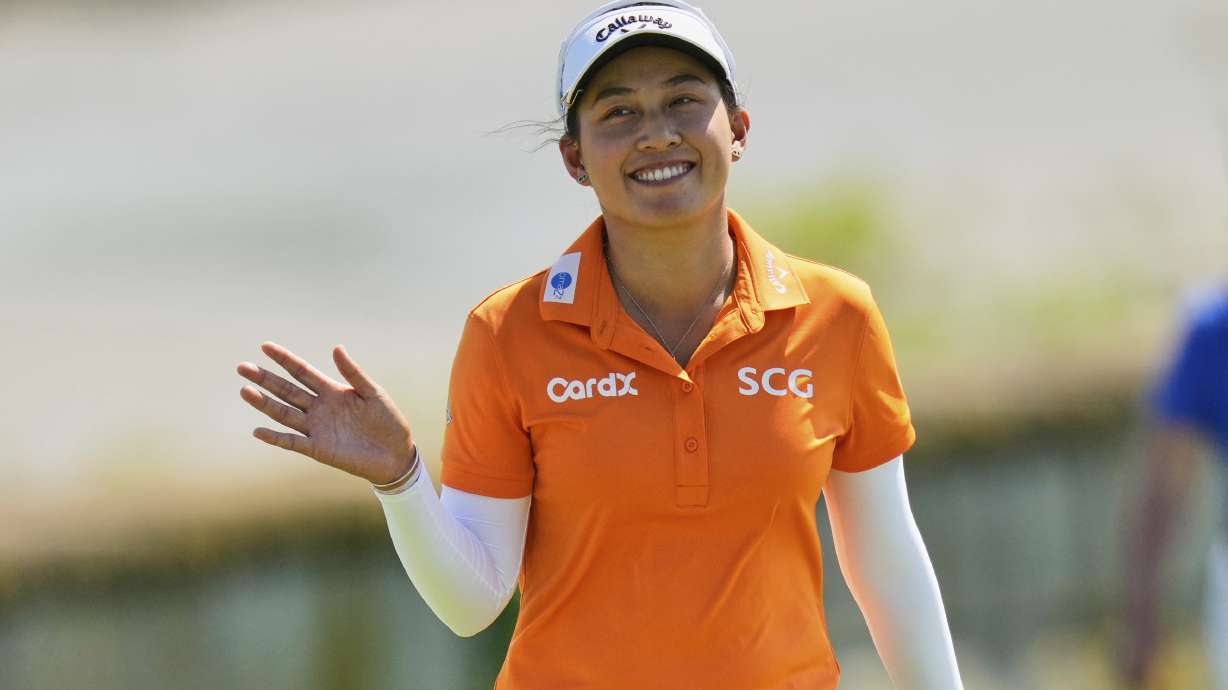 Jeeno Thitikul, of Thailand, waves as she arrives on the 18th green during the final round of the Mizuho Americas Open LPGA golf tournament, Sunday, May 11, 2025, in Jersey City, N.J.