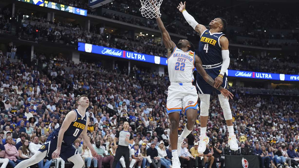 Oklahoma City Thunder guard Cason Wallace (22) drives to the basket as Denver Nuggets guards Christian Braun (0) and Russell Westbrook (4) defend in the second half of Game 4 in the Western Conference semifinals of the NBA basketball playoffs Sunday, May 11, 2025, in Denver.