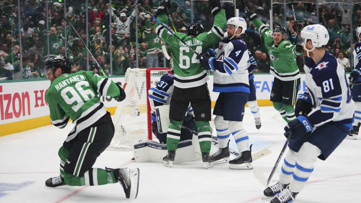 Dallas Stars' Mikko Rantanen (96), Mikael Granlund (64) and Roope Hintz, rear, celebrate Rantanen's goal as Winnipeg Jets' Neal Pionk (4) and Kyle Connor (81) look on in the third period of Game 3 of a second-round NHL hockey playoff series in Dallas, Sunday, May 11, 2025.