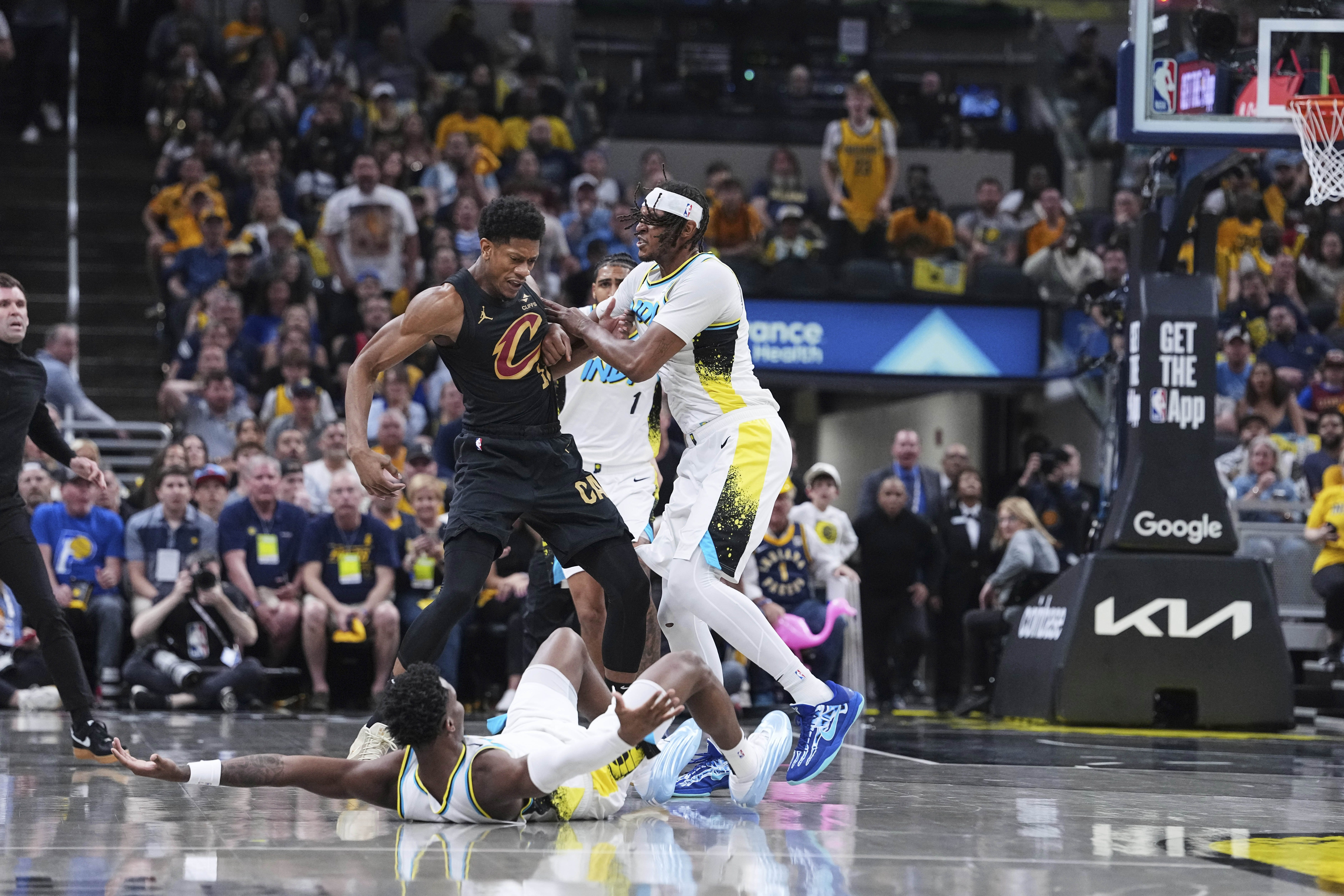 Indiana Pacers guard Bennedict Mathurin (00) falls to the court as center Myles Turner pushes Cleveland Cavaliers forward De'Andre Hunter (12) in the first half of Game 4 in the Eastern Conference semifinals of the NBA basketball playoffs in Indianapolis, Sunday, May 11, 2025.