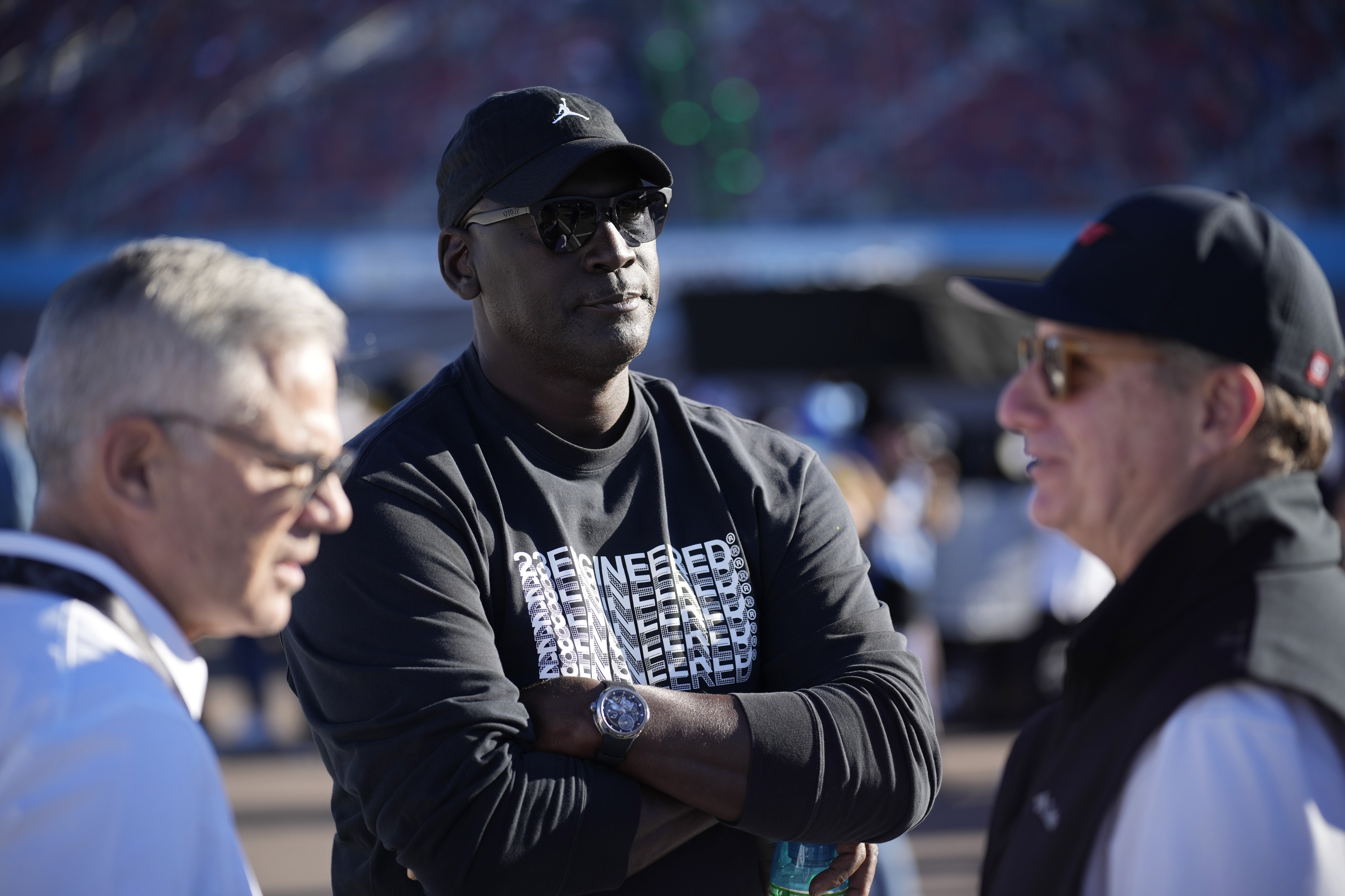 FILE - Michael Jordan, center, and Curtis Polk, left, co-owners of 23XI Racing, watch during qualifying beside 23XI Racing President Steve Lauletta, right, for a NASCAR Cup Series Championship auto race, Nov. 9, 2024, in Avondale, Ariz.
