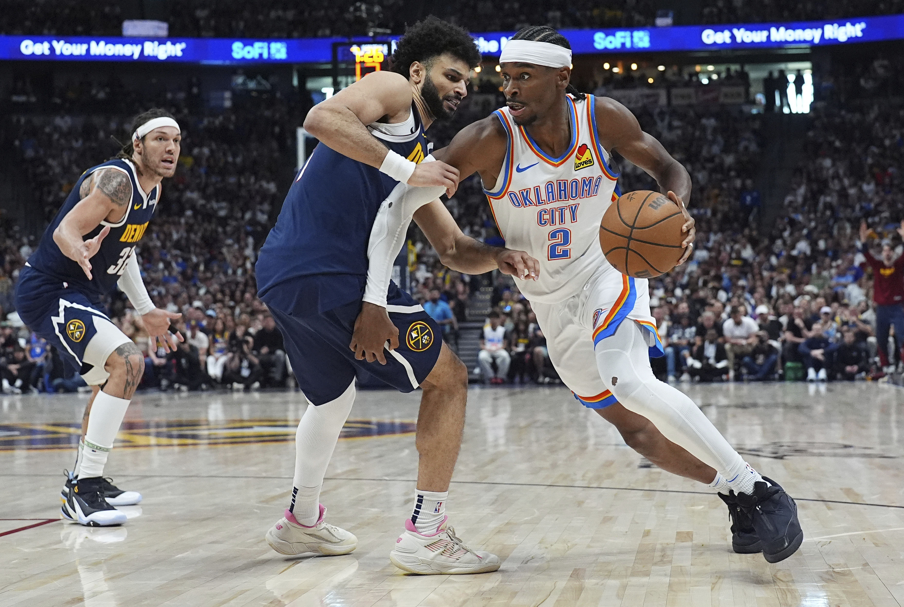 Oklahoma City Thunder guard Shai Gilgeous-Alexander, right, drives past Denver Nuggets guard Jamal Murray, center, and forward Aaron Gordon in the second half of Game 4 in the Western Conference semifinals of the NBA basketball playoffs Sunday, May 11, 2025, in Denver.