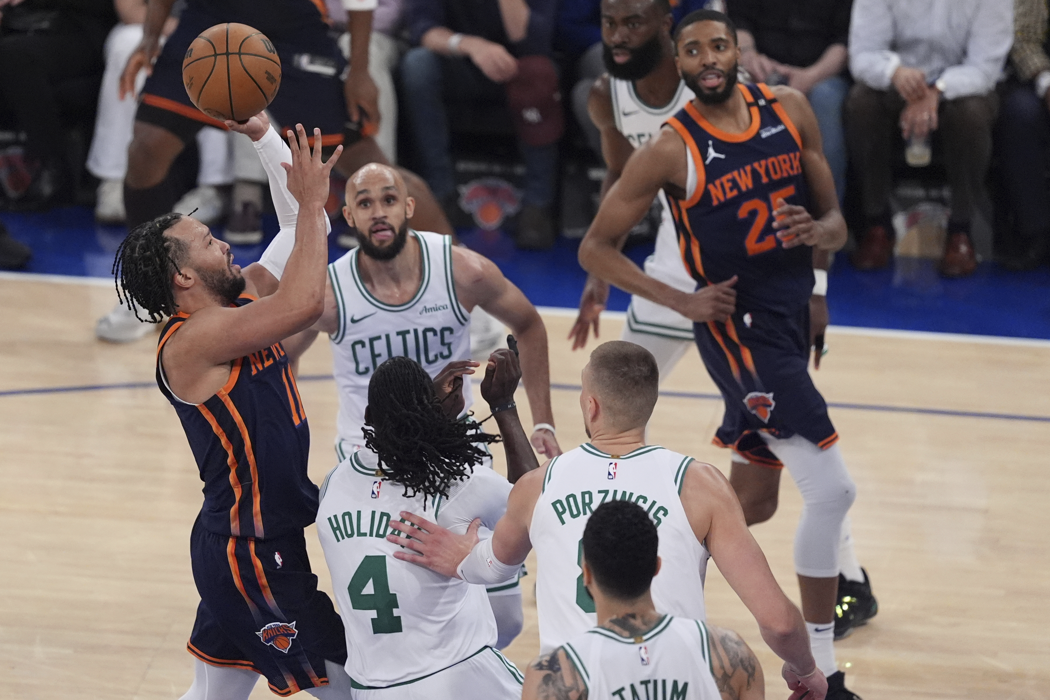New York Knicks' Jalen Brunson, left, shoots over Boston Celtics' Jrue Holiday (4) and Derrick White (9) during the first half of Game 4 in the Eastern Conference semifinals of the NBA basketball playoffs Monday, May 12, 2025, in New York.