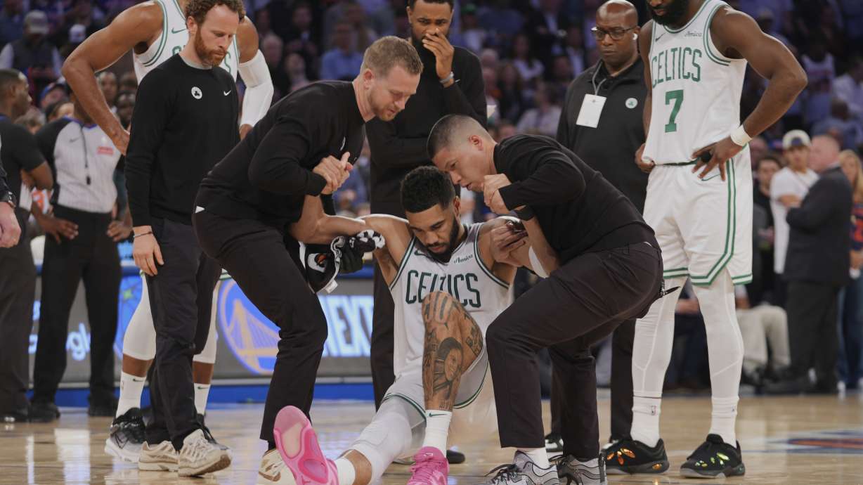 Trainers help Boston Celtics' Jayson Tatum (0) off the court after he was injured during the second half of Game 4 in the Eastern Conference semifinals of the NBA basketball playoffs against the New York Knicks Monday, May 12, 2025, in New York.