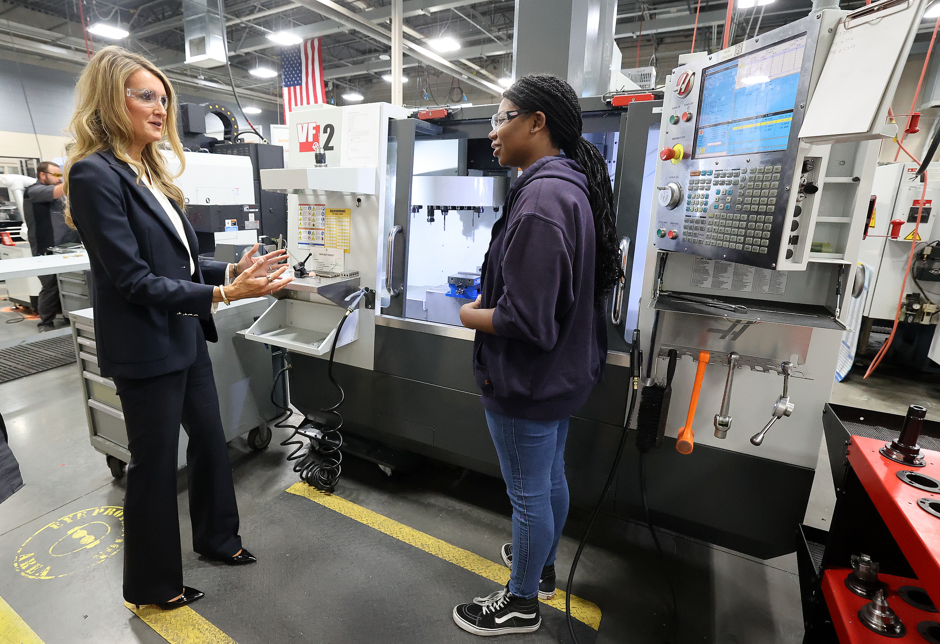 Kelly Loeffler, the 28th administrator of the U.S. Small Business Administration, talks to student Tiara Thompson as Thompson works with a Haas VF-2 3-axis mill at Davis Technical College in Kaysville on Tuesday.