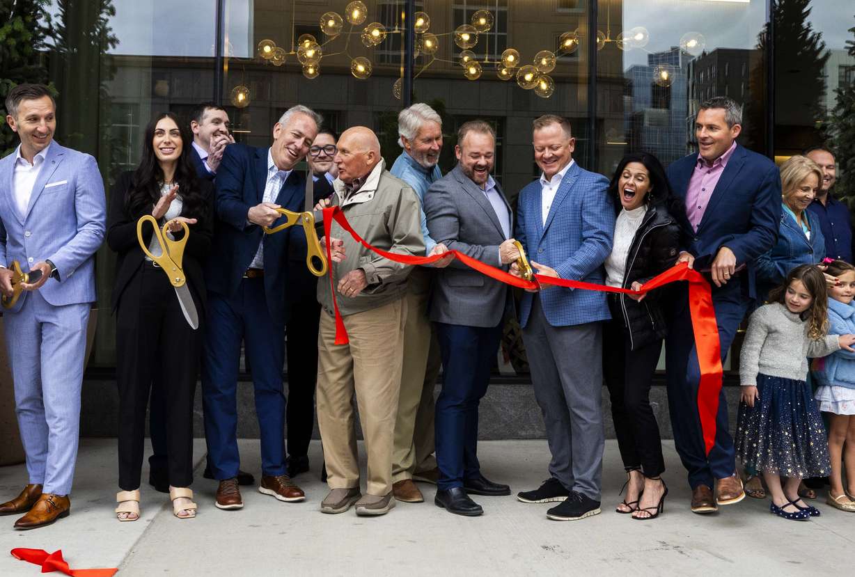 Employees, friends and family of the Kensington Investment Company celebrate as they perform a ribbon-cutting at the grand opening for the Astra Tower in Salt Lake City on Tuesday.