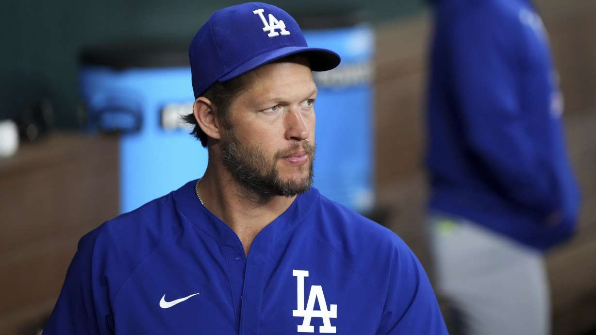 Los Angeles Dodgers starting pitcher Clayton Kershaw, who is on the 60-day injured list with a left toe injury, looks on from the dugout before a baseball game against the Texas Rangers, Saturday, April 19, 2025, in Arlington, Texas.