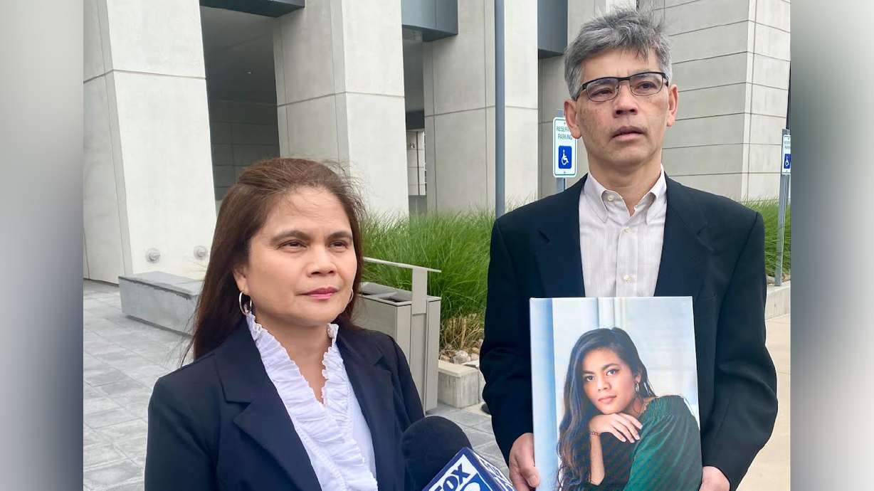 Rose and Keith Nguyen hold a picture of their daughter, Rena, outside 4th District Court in Provo on Tuesday. Rena Nguyen's boyfriend, Caleb Aidan Rees, is charged with manslaughter and accused of abusing Rena during a tumultuous relationship.