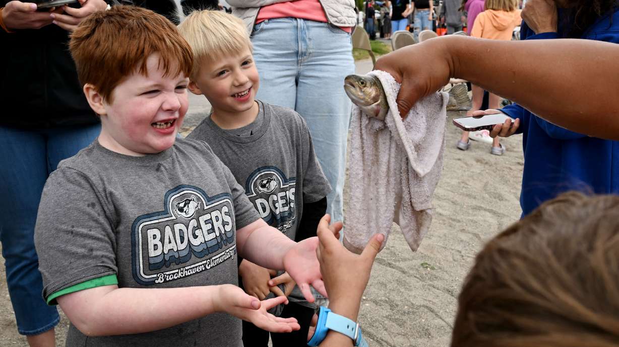 Nate Coles and Lincoln Anderson look at a fish as they and other kids fish as the Division of Wildlife Resources holds a fishing day at Salem Pond to help children and young adults with special needs catch fish on Tuesday.